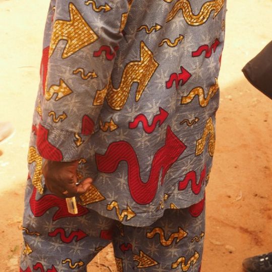 Detail of a man wearing a wax-print suit decorated with the design Flèche New at the Royal Palaces of Abomey, Benin on May 20, 2015 (photo by Luise Illigen)