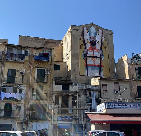 A street in Palermo, several big buildings in the background.