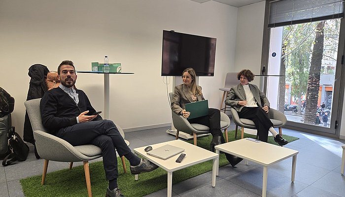 Three panelists sitting in chairs in a seminar room