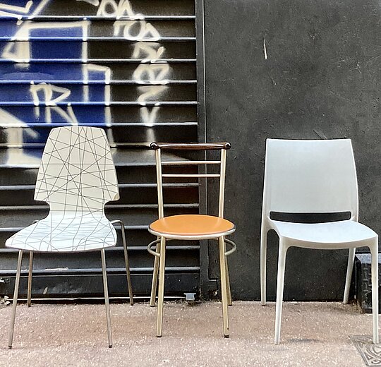 Photo of three empty chairs on a street