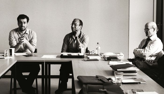 Three men discussing.