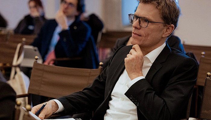 A man sitting in the audience, listening